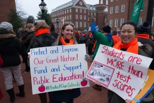 teachers hold signs protesting student testing