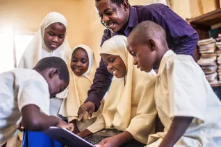 male teacher with students in international classroom
