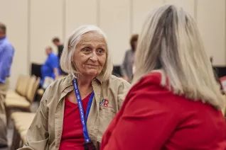 two nea-retired members talk during a break in a conference