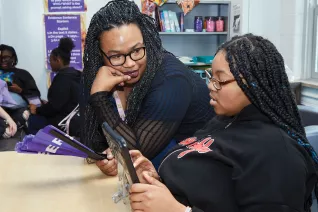 Kennita Ballard works with a student in the classroom