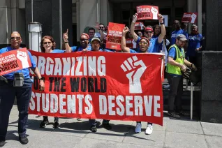 A group of NEA members with a banner that says "organizing for the world students deserve"