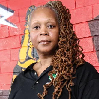 Closeup shot of Kimberly Reece against a painted brick wall