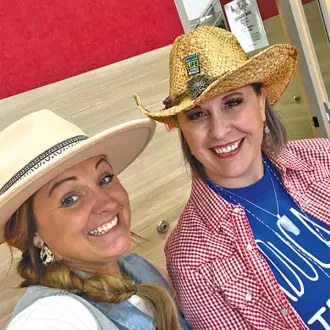 Shawna Blamires and Mikkel Willard take a selfie together wearing cowboy hats