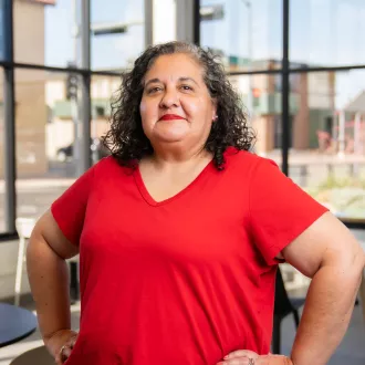 Photo of Amy Garcia in red shirt, hands on hips