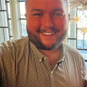 A selfie of a man smiling and looking directly at camera.
