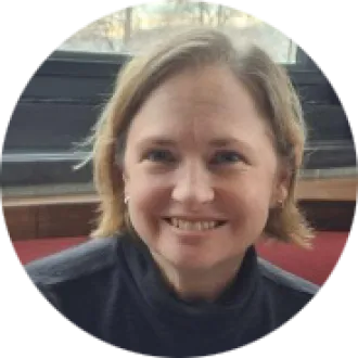 A woman with short hair smiles at the camera.