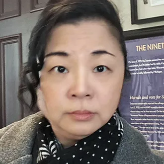 A woman with a serious expression looking straight to camera.