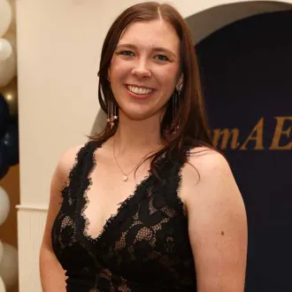 A woman with a bright smile poses in front of the camera.