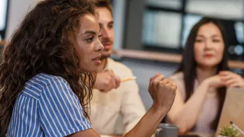 A woman speaks in a meeting