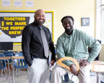 Two teachers spend their break together and smile at the camera.