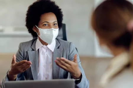 Colleagues meet while wearing masks