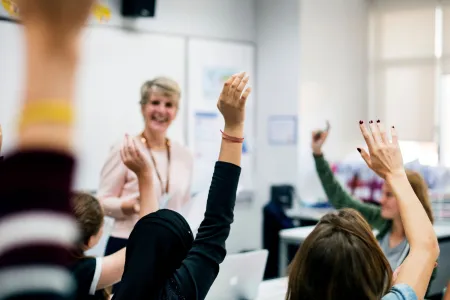 teacher with classroom raising hands