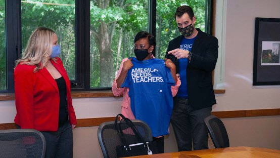 NEA President Becky Pringle holds up a t-shirt reading "America Needs Teachers" with Iowa Senate Democratic Leader Zach Wahls