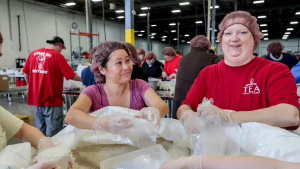 Two NEA members fill bags with food