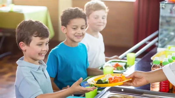 Group of young male  students stand in line for school lunch 