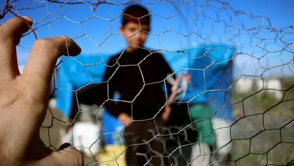 A child appears behind a fence