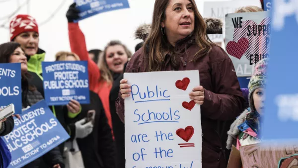 A crowd of people holding various signs about supporting public education.