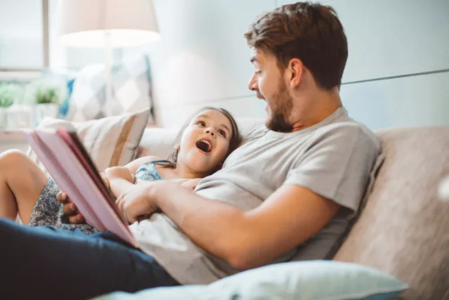 A father reads to his daughter