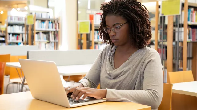 young woman on computer in college library