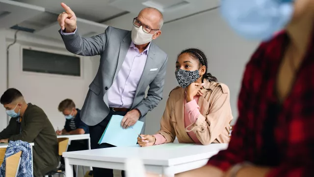 Higher ed professor explaining something to student