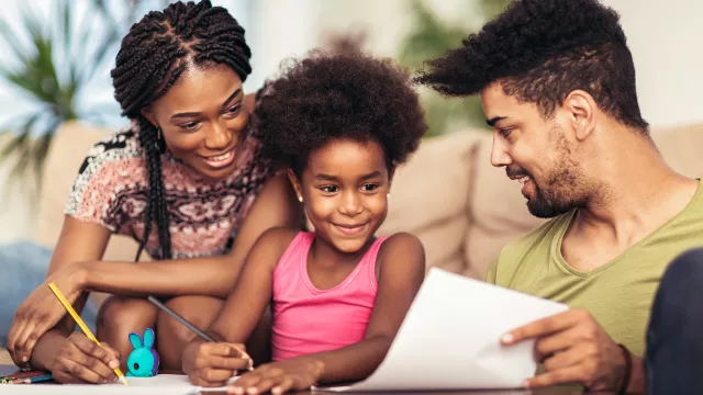 mother and father helping child with homework