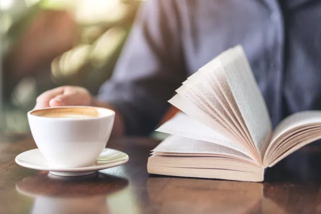 closeup of a coffee cup and book