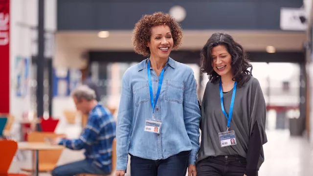 Two teachers walk through a hallway