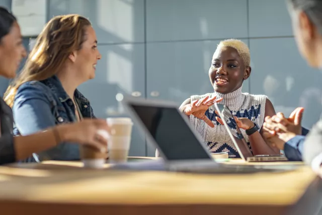 a diverse group of people sitting at a table conversing