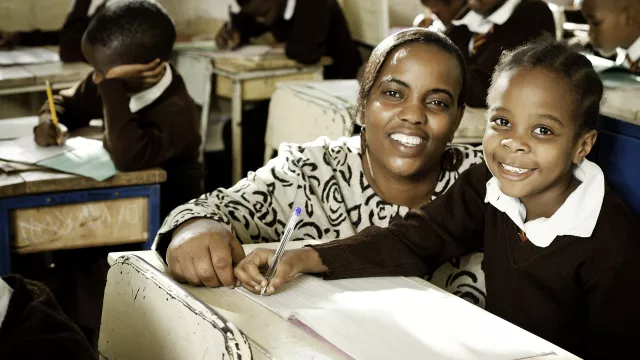African female teacher with student in classroom