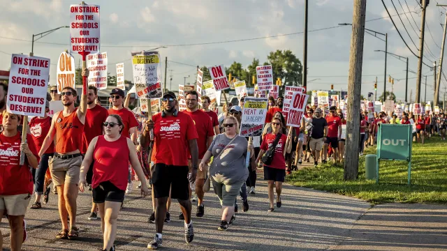 educators and their community wearing red on a picket line