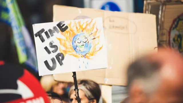 A climate action sign reading, "Time Is Up"