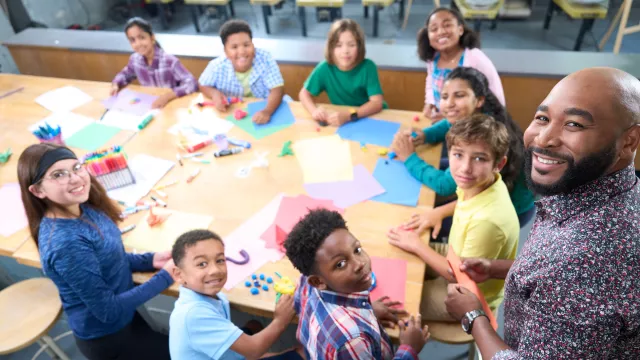 Teacher with group of students at table
