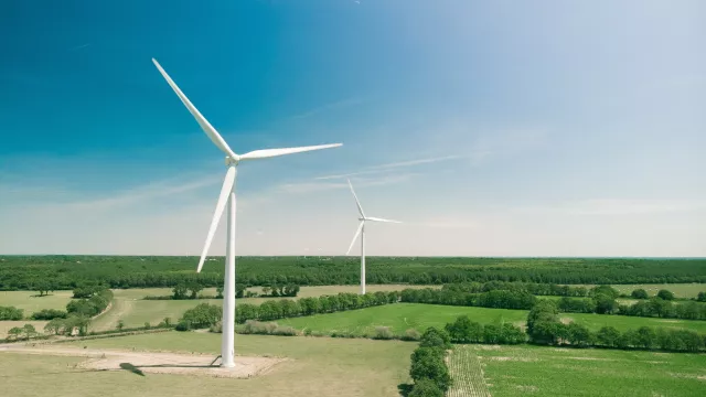 Wind turbine in a green field with a blue sky
