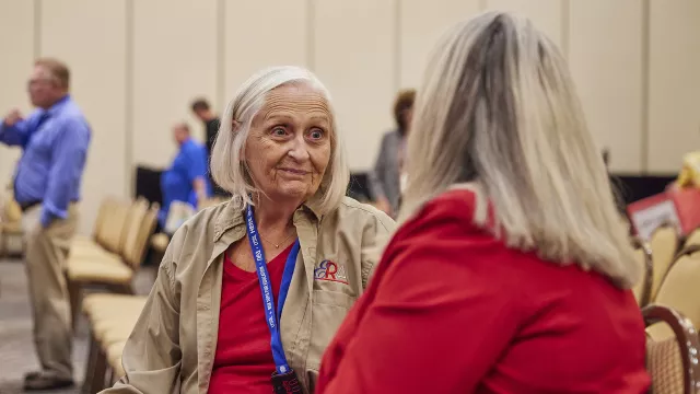 two nea-retired members talk during a break in a conference