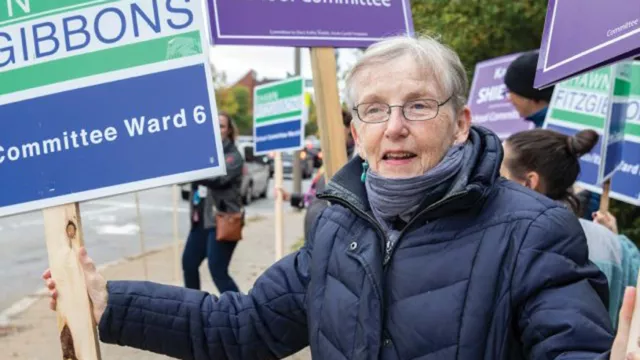 Jane Franz outside with protest signs