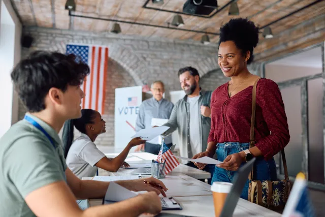 African american woman gets her ballot to vote at a polling place