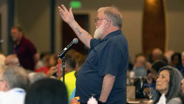 NEA-Retired member stands and addresses a room of conference attendees