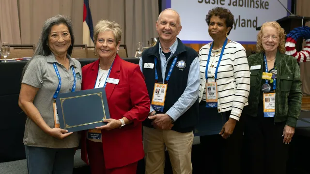 Awardees at the NEA-Retired 2026 annual meeting stand with their award and NEA-Retired President