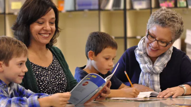 teacher and paraeducator with students