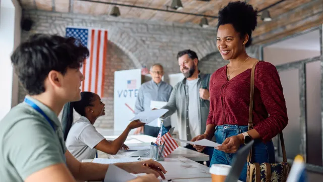African american woman gets her ballot to vote at a polling place