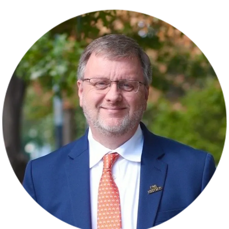 Headshot of 2026 NEA Higher Educator of the Year Clinton Smith wearing a blue suit and orange tie