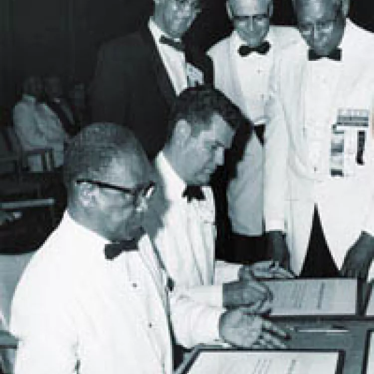 ATA President R.J. Martin and NEA President Richard D. Batchelder (seated) seal the merger