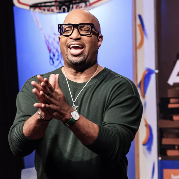 Kwame Alexander in a dark green shirt with hands clasped