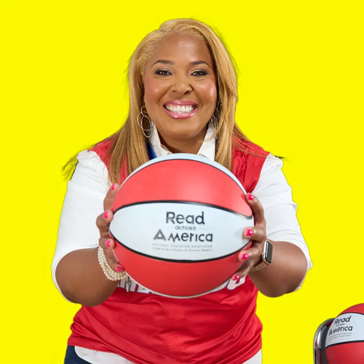 Helen Darling looks at camera smiling while she holds a Read Across America basketball