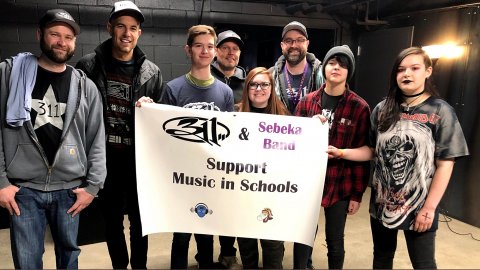High school band students with members of the 311 rock group