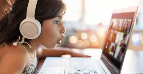 young girl with headphones during phonics lesson online