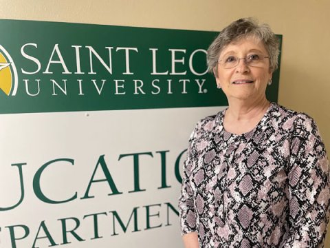 Florida retiree Beverly Ledbetter In front of a Saint Leo University sign.