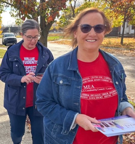 Michigan members in red t-shirts walking neighborhood before election