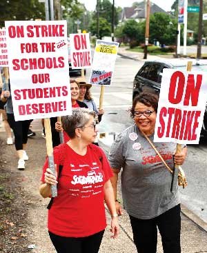 NEA VP Princess Moss picketing with CEA members with signs that say, On Strike, and On Strike for the Schools Our Students Deserve.