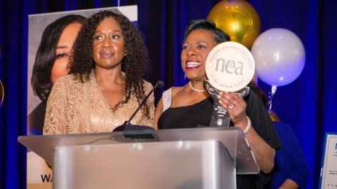NEA President Becky Pringle stands at a podium with 2023 Education Support Professional of the Year Pamella Johnson